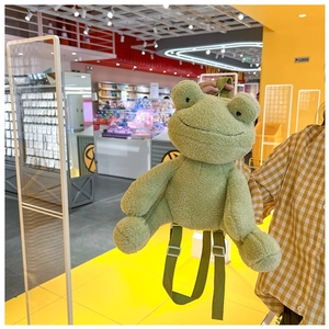 Detail of green plush frog backpack showing soft texture and adjustable shoulder straps