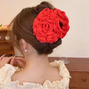 Detailed back view of a large red fabric rose flower hair claw clip on an elegant updo