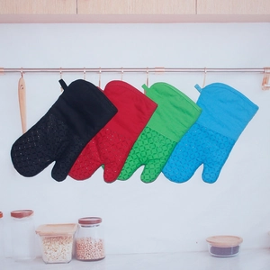Close-up of four colorful silicone and cloth heat-resistant oven mitts hanging in kitchen