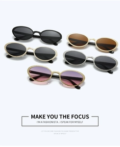 Detail of trendy oval sunglasses featuring textured metallic frames and gradient lenses