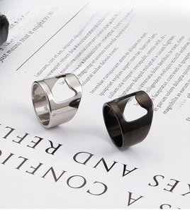 Detail view of silver and gunmetal stainless steel bottle opener rings on white paper