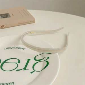 Detail of white marble textured acetate headband with non-slip teeth on a plate