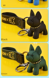 Detail of French bulldog keychains in blue, black, and green with leather straps
