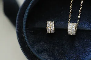 Detail view of 14K gold plated S925 silver cylinder necklace with shimmering zircon stones