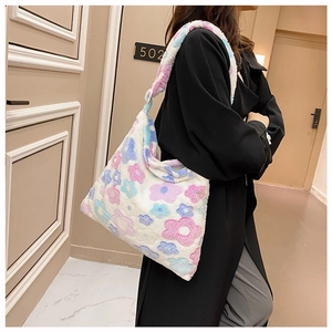 Detailed view of plush white floral tote bag with soft pink and blue flower patterns