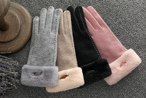Flat lay of warm winter gloves in grey, beige, black and pink with faux fur trim