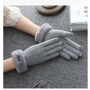 Detail of warm grey plush gloves with knitted cuffs shown in a cozy aesthetic setting