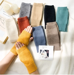 Flat lay of colorful knitted fingerless gloves in yellow, grey, and khaki shades