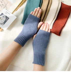 Detailed close-up of colorful knitted fingerless gloves showing ribbed cuffs and soft yarn