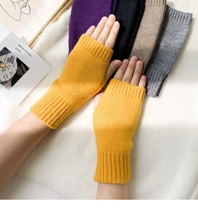Detail of yellow knitted fingerless gloves showing wool texture and elastic ribbed cuffs