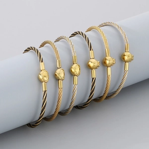 Detail showing various 3mm stainless steel cable bracelets with heart and bead charms