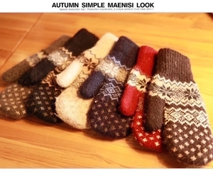 Detail of warm knit mittens featuring snowflake patterns and festive wave textures