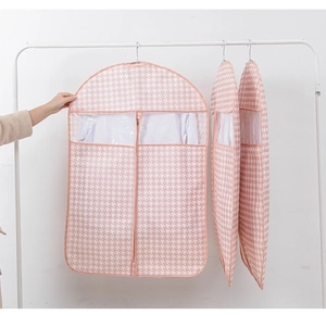 Detail of pink houndstooth garment bag with central zipper and clear PVC window