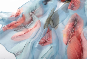 Detail of soft blue chiffon scarf showing elegant feather patterns and silky texture