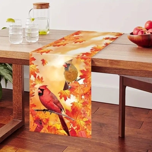 Harvest table runner featuring autumn maple leaves and northern cardinals on wooden dining table