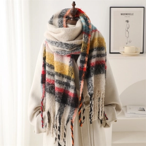 Winter plaid scarf with tassels in soft beige and red checks on a lifestyle mannequin