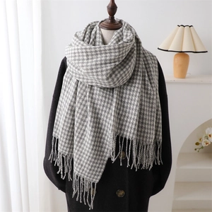 Classic houndstooth scarf with tassels, soft grey and white warm shawl on a mannequin
