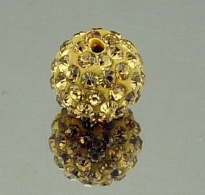Macro shot of 8mm golden rhinestone-encrusted pave clay bead showing detail of the through-hole