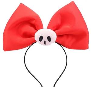 Detail of red bow headband featuring a white skull centerpiece for Halloween parties
