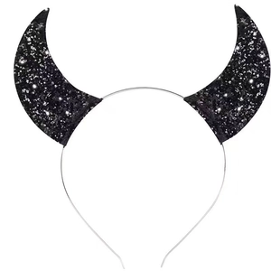 Detail view of black sequined devil horns on a slim silver metal headband for party