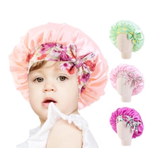 Detail of baby satin sleep caps featuring floral bows in pink and pastel colors