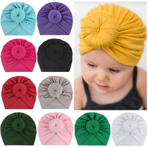 Detail of multi-color velvet baby donut turban hats with soft texture and knotted design