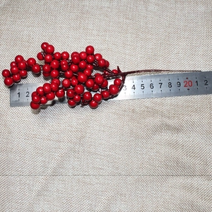 Close-up of artificial red berry branch with a ruler showing 20cm total length