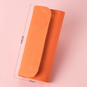 Orange makeup brush bag with lychee texture leather detail and 20.5cm x 9.5cm dimensions