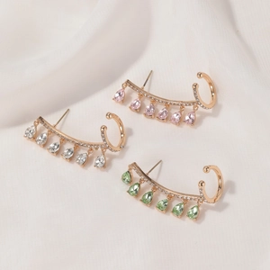Detail of rose gold ear cuffs with pink, clear, and green teardrop crystal tassels
