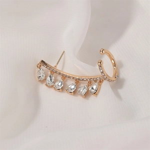 Detailed view of a gold-toned ear cuff with sparkling teardrop-shaped tassels on silk