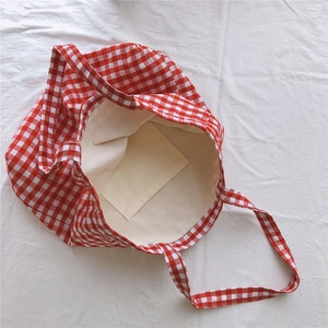 Close-up of red and white gingham tote bag featuring internal pocket and soft lining