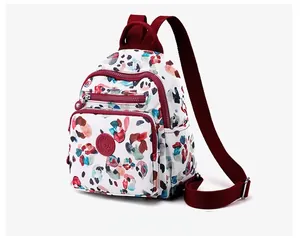 Detail of white nylon mini backpack with colorful print and burgundy adjustable straps