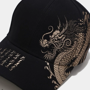 Dettaglio della stampa del dragone dorato e calligrafia cinese su cappello nero