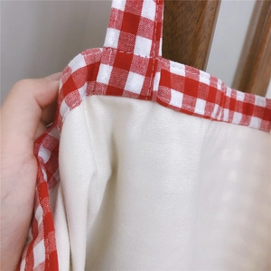Detailed close-up showing the fine stitching and thick red gingham canvas fabric texture