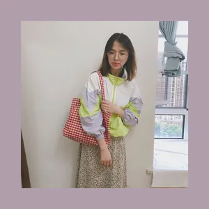 Lifestyle shot of a vintage red and white gingham canvas tote bag worn by a model