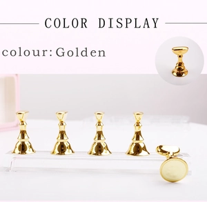Detail of golden chess-piece nail art stands on a clear acrylic display base