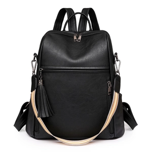 Detail of black pebbled PU leather backpack with tassel charm and striped strap