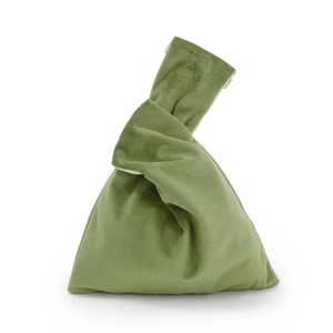 Detail view of green velvet knot handbag with soft fabric texture and cream lining
