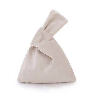 Detailed view of beige velvet wrist bag featuring a unique knotted handle design