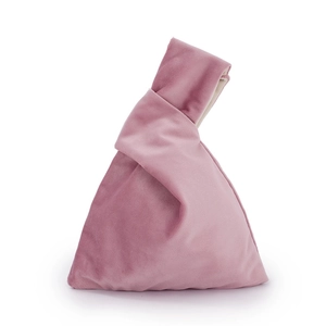 Detailed shot of pink velvet knot handbag with soft fabric texture and triangular shape