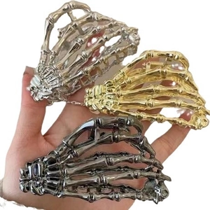 Three metal skeleton hand hair claws in gold, silver, and grey for Halloween styling