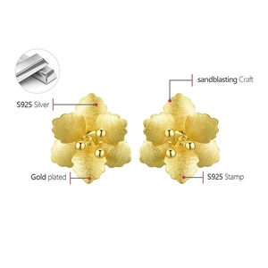 Detail of S925 silver flower earrings with gold plating and sandblasted texture