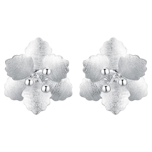 Macro shot of 925 silver flower earrings with frosted texture and polished stamen