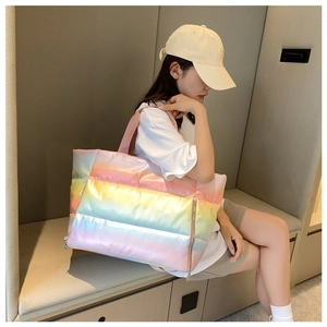 Quilted puffer tote bag in rainbow gradient finish shown in a lifestyle model shot