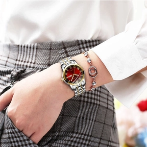 Women's quartz watch with red dial and silver-gold stainless steel band on wrist