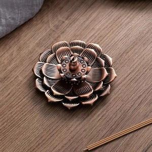 Détail d'un brûleur d'encens en forme de lotus en cuivre antique sur table en bois