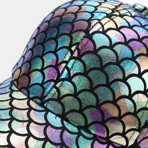 Macro shot of colorful fish scale texture and stitching detail on a baseball cap
