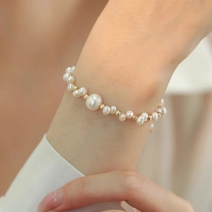 Bracciale intrecciato di perle d'acqua dolce con perle dorate al polso