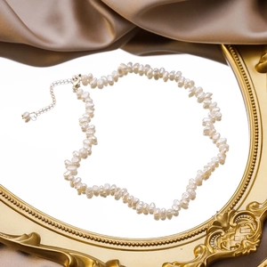 Baroque petal freshwater pearl necklace on vintage gold mirror with silk background