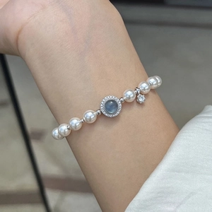 Elegant pearl bracelet featuring a blue zircon centerpiece and sparkling star charm